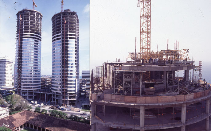 Two images one showing the twin towers on the Colombo World Trade Center reaching completion with the towers being attached with glass. Second image shows the top of one of the towers still under construction.